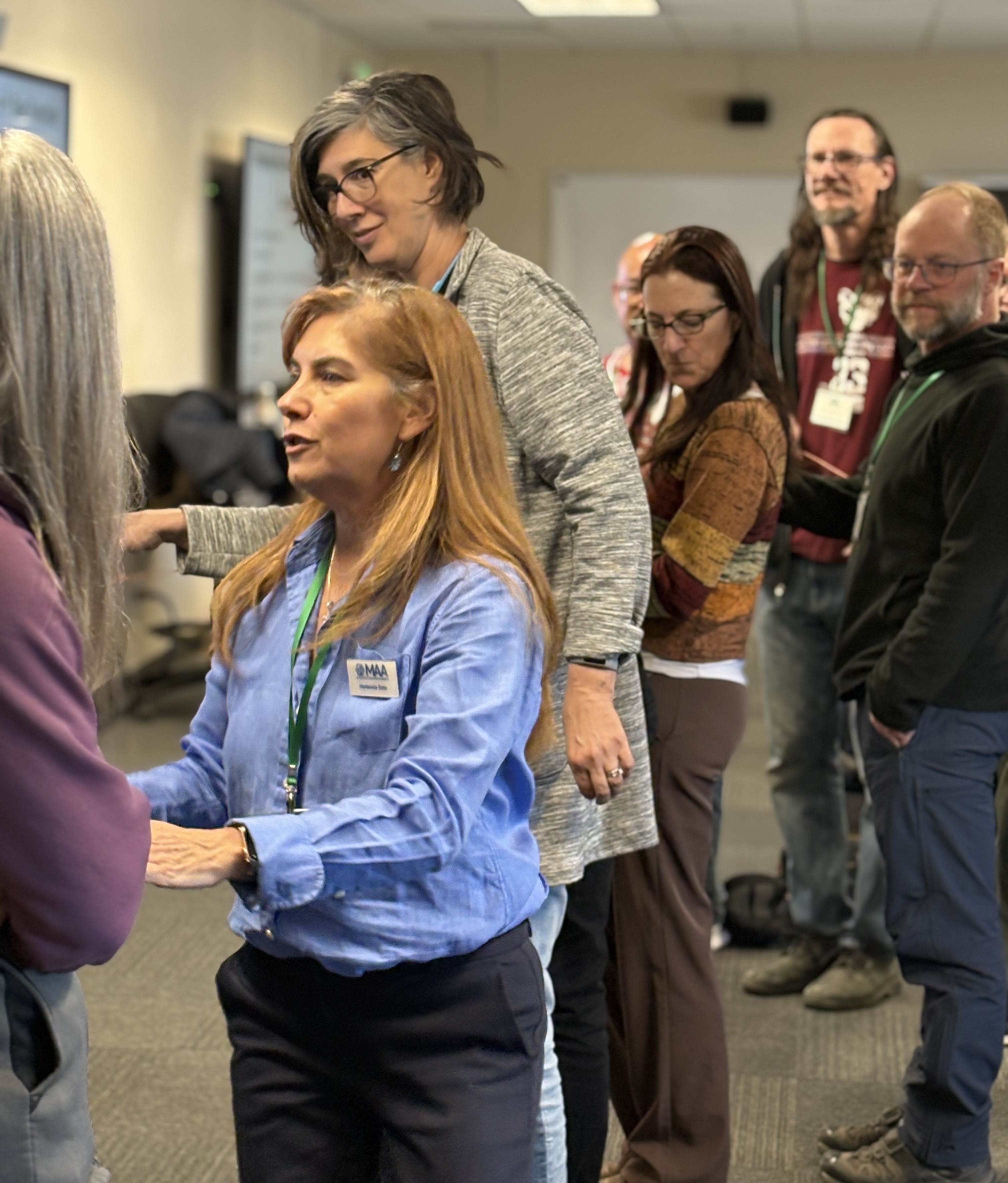 Photo of math educators unraveling the circle of string to construct the sine curve.